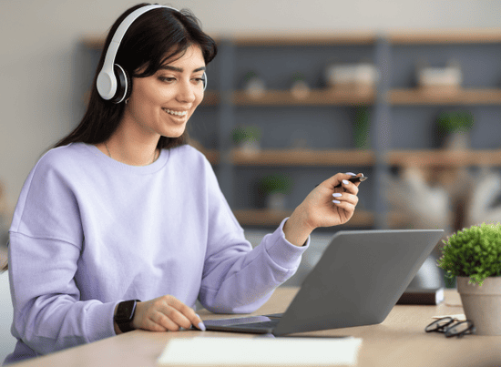 Financing options for studying in Peru University student wearing headphones reviewing financing options on a laptop.